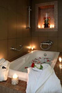 a bathroom with a bath tub with towels and candles at Le Sphinx Boutique H&ocirc;tel in Mohammedia