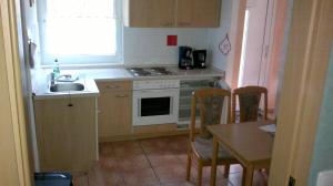 a kitchen with a sink and a stove and a table at Ferienpark Retgendorf in Retgendorf