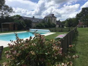 una piscina di fronte a una casa di Domaine de Montgenoux a Prissac
