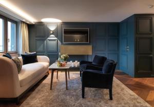ein Wohnzimmer mit einem Sofa, einem Tisch und Stühlen in der Unterkunft Hotel Zürserhof in Zürs am Arlberg