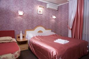 Schlafzimmer mit einem roten Bett und lila Wänden in der Unterkunft Paradise Hotel in Homel