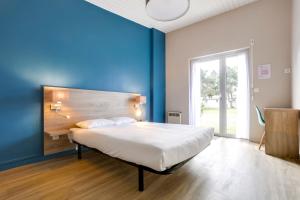 ein Schlafzimmer mit einem großen Bett mit blauer Wand in der Unterkunft Azureva Hauteville in Hauteville-sur-Mer