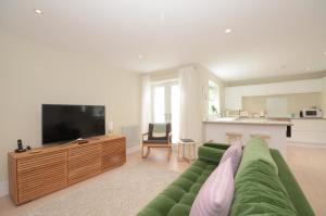 ヨークにあるThe Mews - 2 Bedroom Luxury, Spacious House With Free Parkingのリビングルーム(緑のソファ、薄型テレビ付)