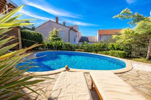 a swimming pool in the backyard of a house at Villas Rab Banjol in Rab