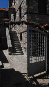 a gate in front of a stone building with stairs at Luxurious Residence at the Village Square in Palaios Agios Athanasios