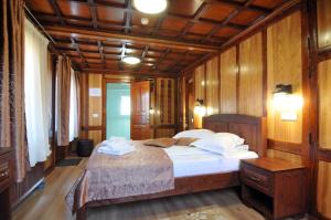 una camera con letto, pareti in legno e pavimenti in parquet di Pensiunea Manidum a Buşteni