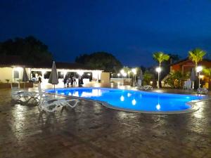 a large blue swimming pool at night at Feudo delle Querce in Vena