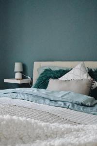 1 dormitorio con 1 cama con pared azul en AJ - tér apartman miskolc en Miskolc