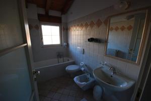 a bathroom with a sink toilet and a mirror at Garni Viggiona in Trarego +42 photos