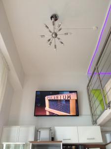 uma sala de estar com televisão e tecto em City Apartment Munich em Munique