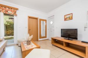 a living room with a television and a couch at Villas Rab Banjol in Rab