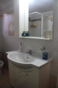 y baño con lavabo y espejo. en Quiet spacious apartment in Nafplio, en Nauplia