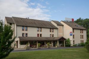 een groot gebouw met een picknicktafel ervoor bij The Originals City, Hôtel Amys, Tarbes Sud (Inter-Hotel) in Odos