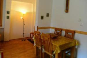 a dining room with a table and chairs and a lamp at Vučko Apartment in Bjelašnica