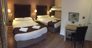 A bed or beds in a room at Gatwick Belmont Hotel