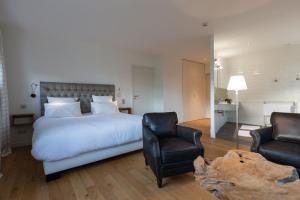 a bedroom with a large bed and two chairs at le clos des belvals in Vertus