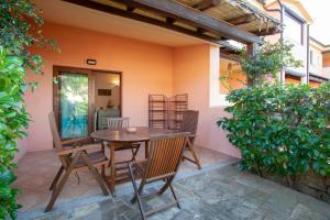 einen Holztisch und Stühle auf einer Terrasse in der Unterkunft Appartamento Mare Olbia – Murta Maria in Olbia