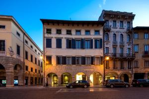 grupa budynków z samochodami zaparkowanymi na ulicy w obiekcie Mercatovecchio Luxury Suites w mieście Udine