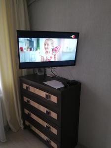 a flat screen tv sitting on a dresser with a television on it at Апартаменты на Ивана и Юрия Лип in Odesa