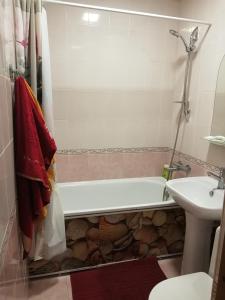 a bathroom with a bath tub and a sink at Апартаменты на Ивана и Юрия Лип in Odesa +7 photos