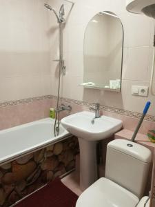 a bathroom with a sink and a toilet and a mirror at Апартаменты на Ивана и Юрия Лип in Odesa