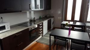 Una pequeña cocina con una mesa y un microondas. en Cool Guesthouse, en Oporto