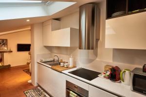 una cocina con armarios blancos y fregadero en la casa di Veronique, en Como