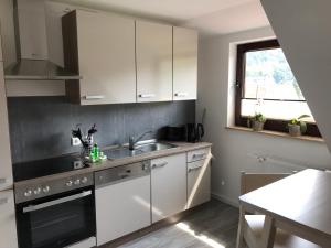 a kitchen with white cabinets and a sink and a window at Harzer Ferienlodge in Wernigerode
