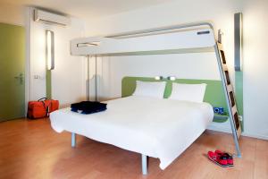 a bedroom with a white bed with a canopy at ibis budget Romorantin in Romorantin
