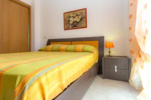 a bedroom with a bed with a yellow bedspread at Bilocale Giulia in Casa Alzi