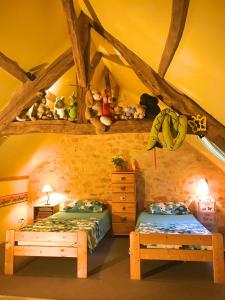 a bedroom with two beds and stuffed animals on the ceiling at Maison La Mouline in Groléjac