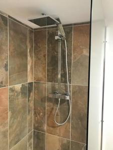 La salle de bains est pourvue d'une douche avec un tuyau. dans l'établissement Maison La Mouline, à Groléjac