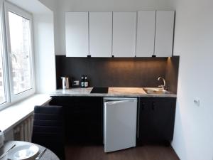 a kitchen with black and white cabinets and a sink at Tilžės gatvė 144 in Šiauliai