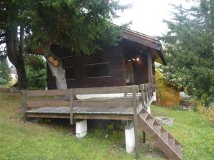 eine Holzbank vor einem kleinen Haus in der Unterkunft HAMEAU DU RUISSEAU in Manigod