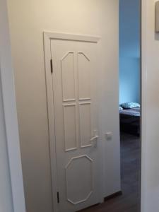 a white door in a room with a bed at Tilžės gatvė 144 in Šiauliai