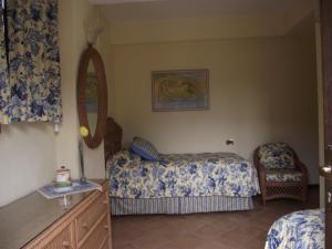 a bedroom with a bed and a chair at Villa Castiglioni Apartment in Laglio