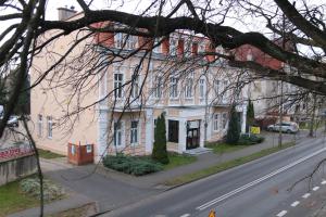 a large white building on the side of a street at Hotel Polonia in Chojnice
