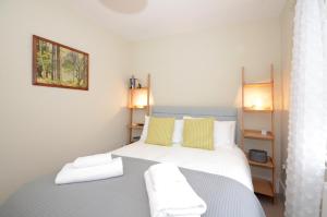 a bedroom with a large bed with yellow and white pillows at The Mews - 2 Bedroom Luxury, Spacious House With Free Parking in York