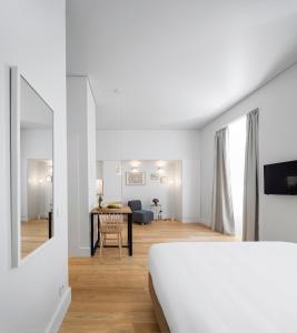 een witte slaapkamer met een bed en een eetkamer bij Lisbon Serviced Apartments - Benformoso in Lissabon