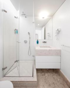 een witte badkamer met douche en wastafel bij Lisbon Serviced Apartments - Benformoso in Lissabon