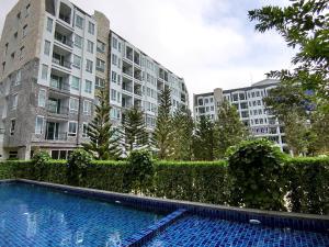 una piscina frente a dos edificios altos en The Courtyard Khaoyai, en Mu Si