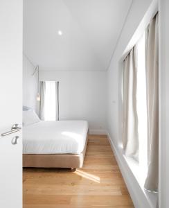 a bedroom with a white bed and white walls at Lisbon Serviced Apartments - Benformoso in Lisbon