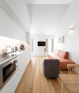 een keuken en woonkamer met een bank en een tafel bij Lisbon Serviced Apartments - Benformoso in Lissabon