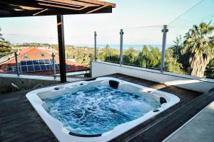 阿茨特雷扎的住宿－Sicilia's Art Hotel & Spa，房屋甲板上的按摩浴缸