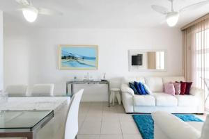 a living room with a white couch and a table at Barra Family Resort - 3 Quartos in Rio de Janeiro