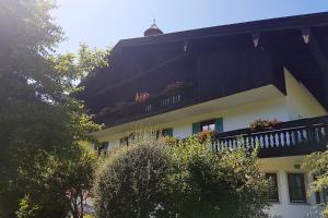 ein Gebäude mit einem Balkon mit Blumen darauf in der Unterkunft Gschwendtnerhof in Aschau im Chiemgau