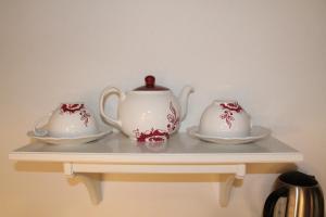 a shelf with two tea pots and saucers on it at La Soffitta in Bologna