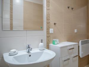 a bathroom with a white sink and a mirror at Dream Bay Apartment in Gdańsk