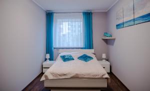 a bedroom with a bed with two blue pillows at Dream Bay Apartment in Gdańsk