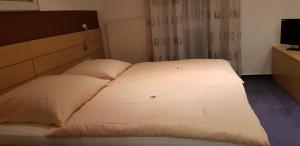 a bed in a hotel room with two pillows at Hotel Habana in Aalen